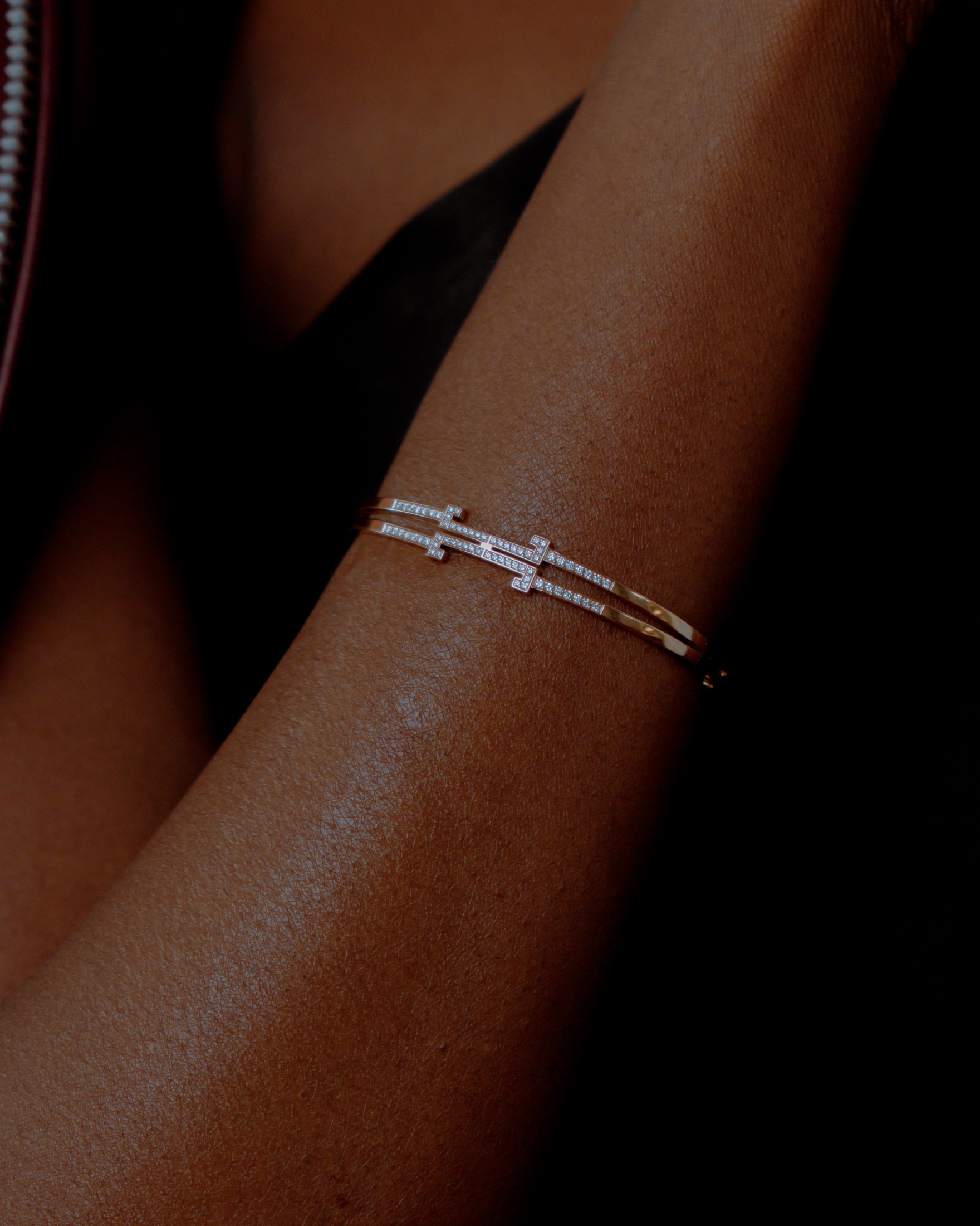 Le Bracelet Éternel TEONAR porté au poignet — le double-T en pavé de diamants sur un jonc d'or.