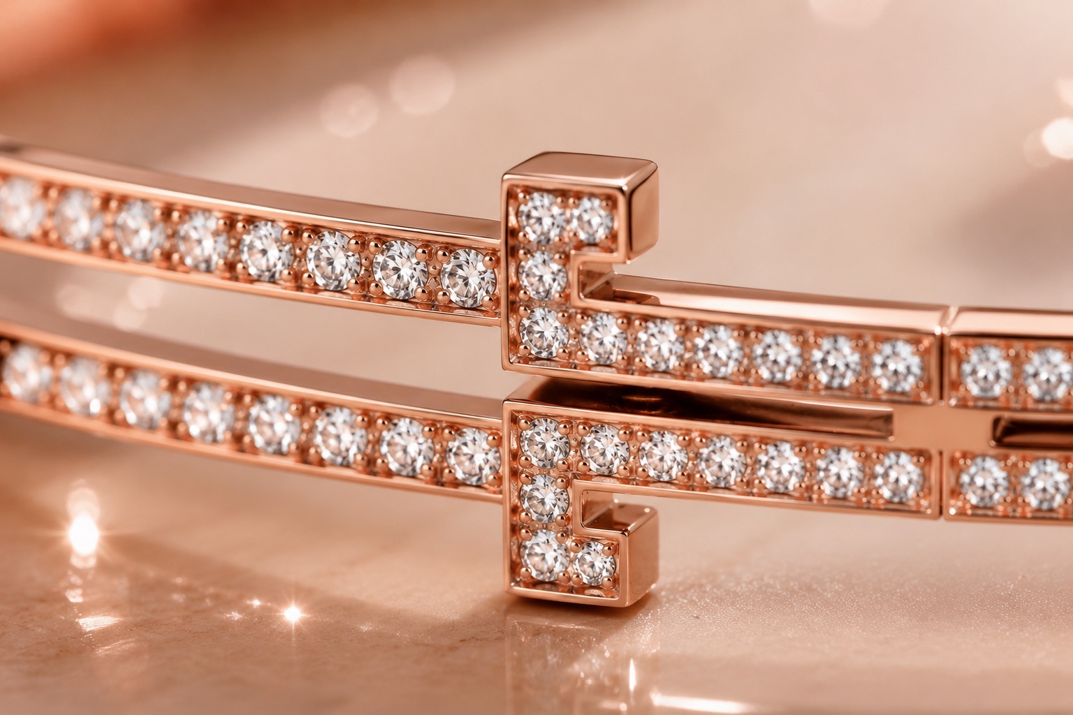 Macro du Bracelet Éternel — les deux « T » sertis de diamants sur un jonc d'or rose.